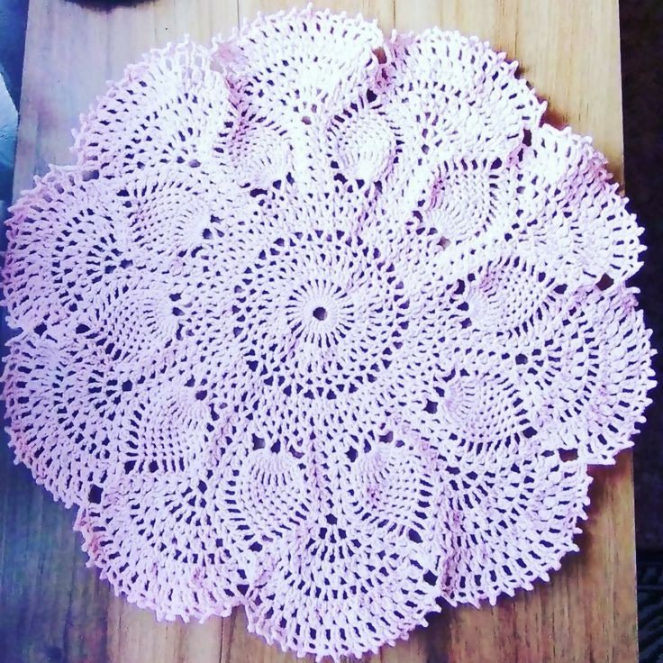 Classic white lace doily on a wooden table.